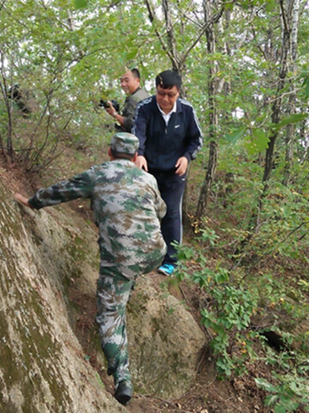 上肥地镇王书记在考察途中协助他人的登山镜头